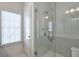 Bathroom featuring a glass shower enclosure, a window, and white marble-style tiling at 6601 Cadence Blvd, Atlanta, GA 30328