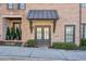 Stylish brick townhome entrances with manicured landscaping and metal awnings at 6601 Cadence Blvd, Atlanta, GA 30328