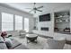 Bright living room with a fireplace, plush seating, a ceiling fan, and large windows for ample natural light at 6601 Cadence Blvd, Atlanta, GA 30328