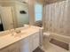 Well-lit bathroom with a single vanity, framed mirror, tiled shower, and neutral colored tile flooring at 272 Lynshire Sw Ct, Marietta, GA 30064