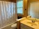 Cozy bathroom with decorative wallpaper, a shower-tub combo, framed mirror, and laminate flooring at 272 Lynshire Sw Ct, Marietta, GA 30064
