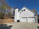 Two-story home featuring white siding, a two-car garage, and a tall chimney against a bright blue sky at 272 Lynshire Sw Ct, Marietta, GA 30064