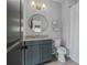 A charming bathroom featuring a vanity, round mirror, neutral paint, and tile floors, offering a clean, modern space at 6845 Wesley Hughes Rd, Cumming, GA 30040