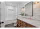 Charming bathroom features patterned wallpaper, a vanity with marble countertop, framed mirror, and a shower-tub combination at 6845 Wesley Hughes Rd, Cumming, GA 30040