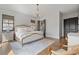 Bright bedroom featuring hardwood floors, neutral decor, natural light, and a comfortable bed at 6845 Wesley Hughes Rd, Cumming, GA 30040