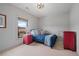 A cozy bedroom featuring a single bed, a red nightstand, and neutral walls creating a soothing atmosphere at 6845 Wesley Hughes Rd, Cumming, GA 30040