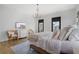 Bright bedroom featuring hardwood floors, a large bed, natural light, and neutral decor at 6845 Wesley Hughes Rd, Cumming, GA 30040