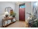 Elegant foyer with wood door, round mirror, console table, and chandelier at 6845 Wesley Hughes Rd, Cumming, GA 30040