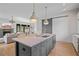 Open kitchen with a large island, stainless steel appliances, pendant lighting, and a seamless living room view at 6845 Wesley Hughes Rd, Cumming, GA 30040