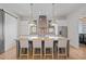 Spacious kitchen with an island, stainless steel appliances, pendant lighting, and adjacent laundry area at 6845 Wesley Hughes Rd, Cumming, GA 30040
