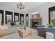 Bright living room featuring a cozy fireplace, large windows, comfortable seating, and a stylish chandelier at 6845 Wesley Hughes Rd, Cumming, GA 30040