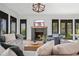Bright living room featuring a cozy fireplace, large windows, comfortable seating, and a stylish chandelier at 6845 Wesley Hughes Rd, Cumming, GA 30040