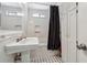 Bright bathroom with tile floors, traditional fixtures, and shower with a black curtain at 9991 Holly Hill Way, Jonesboro, GA 30238