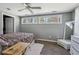 Bedroom with a ceiling fan, wood floors, two windows, and a bed with a brown comforter at 9991 Holly Hill Way, Jonesboro, GA 30238