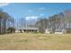 Spacious property featuring a large yard, main house and detached garages against a backdrop of lush trees at 9991 Holly Hill Way, Jonesboro, GA 30238