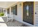 Welcoming front porch with a rocking chair next to the front door at 9991 Holly Hill Way, Jonesboro, GA 30238