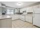 Traditional kitchen featuring white cabinets, tile floors, and matching white appliances at 9991 Holly Hill Way, Jonesboro, GA 30238
