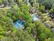 Aerial view of a neighborhood featuring a pool, tennis courts, and mature trees at 10070 Timberstone Rd, Johns Creek, GA 30022