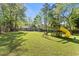 Large backyard with a play structure, a green lawn, and a wooded fence line at 10070 Timberstone Rd, Johns Creek, GA 30022