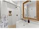 Well-lit bathroom featuring a shower, wooden mirror frame, and a modern sink at 10070 Timberstone Rd, Johns Creek, GA 30022