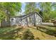 Back view of a single-story home with gray siding, windows, a wooden fence, and a grassy lawn at 10070 Timberstone Rd, Johns Creek, GA 30022