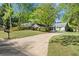 Charming home featuring a well-maintained front yard with mature trees and a circular driveway at 10070 Timberstone Rd, Johns Creek, GA 30022