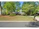 Quaint single-story home with a well-manicured lawn, flowering bushes, and a charming exterior at 10070 Timberstone Rd, Johns Creek, GA 30022
