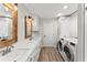 Laundry room with double vanity, bright modern lighting, washer and dryer, and plenty of storage at 10070 Timberstone Rd, Johns Creek, GA 30022