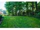 Beautifully landscaped backyard featuring lush green grass and mature trees at 1192 Lake Washington Dr, Lawrenceville, GA 30043