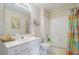 Bright bathroom featuring a white vanity, toilet and a shower-tub combo with a colorful curtain at 1192 Lake Washington Dr, Lawrenceville, GA 30043
