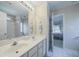 Bathroom with double sinks, white cabinetry, and a view into the bedroom at 1192 Lake Washington Dr, Lawrenceville, GA 30043