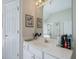 Bathroom vanity with white cabinets, a large mirror, modern fixtures, and ample counter space at 1192 Lake Washington Dr, Lawrenceville, GA 30043