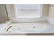 Bright soaking tub with tiled surround and fixtures at 1192 Lake Washington Dr, Lawrenceville, GA 30043