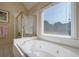 Bright bathroom features a soaking tub and separate shower with gold trim at 1192 Lake Washington Dr, Lawrenceville, GA 30043