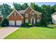 Charming brick two-story home with manicured front lawn and a two-car garage at 1192 Lake Washington Dr, Lawrenceville, GA 30043