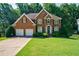 Charming brick two-story home with manicured front lawn and a two-car garage at 1192 Lake Washington Dr, Lawrenceville, GA 30043