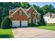 Charming brick two-story home with manicured front lawn and a two-car garage at 1192 Lake Washington Dr, Lawrenceville, GA 30043