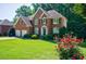 Beautiful brick home with green lawn, manicured shrubs, and vibrant rose bushes at 1192 Lake Washington Dr, Lawrenceville, GA 30043