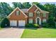 Charming two-story brick home with a well-manicured lawn and beautiful landscaping at 1192 Lake Washington Dr, Lawrenceville, GA 30043