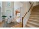 Inviting foyer with a staircase, decorative rug, and view into the dining area at 1192 Lake Washington Dr, Lawrenceville, GA 30043