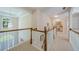 Hallway with white railings and neutral carpet leads to a small desk area and bedrooms at 1192 Lake Washington Dr, Lawrenceville, GA 30043