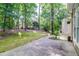 Backyard view with mature trees, green grass and concrete patio at 7045 Threadstone Overlook, Johns Creek, GA 30097