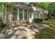 The backyard features a concrete patio, green grass, mature trees and the back of the home at 7045 Threadstone Overlook, Johns Creek, GA 30097