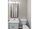 Neutral powder room featuring a wood-trimmed mirror and white vanity at 7045 Threadstone Overlook, Johns Creek, GA 30097