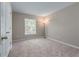 A cozy bedroom featuring neutral walls, carpeted floor, and a large window at 7045 Threadstone Overlook, Johns Creek, GA 30097