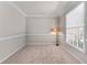 Cozy room featuring neutral carpet, a large window, and ample natural light at 7045 Threadstone Overlook, Johns Creek, GA 30097