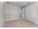 A carpeted bedroom featuring neutral walls and double door closet at 7045 Threadstone Overlook, Johns Creek, GA 30097