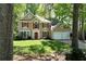 Classic two-story house surrounded by lush trees and a well-kept front yard at 7045 Threadstone Overlook, Johns Creek, GA 30097