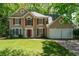 Traditional two-story home featuring red shutters and a well-maintained lawn at 7045 Threadstone Overlook, Johns Creek, GA 30097