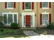 Close up of front door with red shutters and landscaping at 7045 Threadstone Overlook, Johns Creek, GA 30097